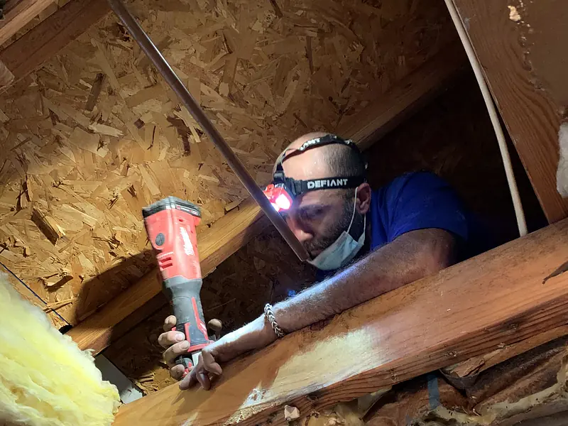 Royal Flush Affordable Plumbing plumber with a headlamp soldering copper pipe in an attic