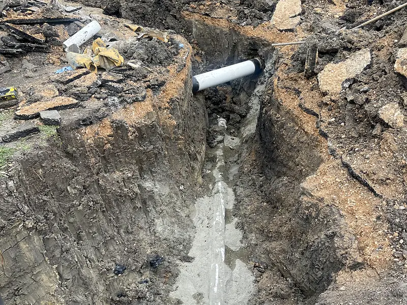 Deep commercial trench with a skid steer and new pipe
