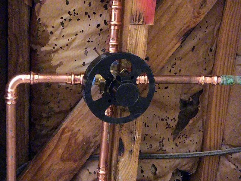 New copper manifold and valve installed in a wall by Royal Flush Affordable Plumbing