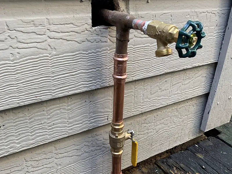 New copper riser and valve on a house with siding