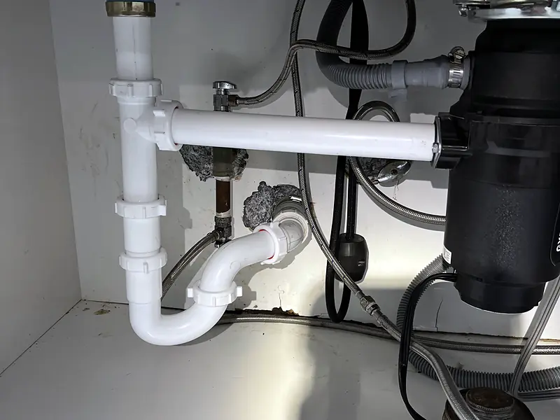 Under-sink plumbing with a new garbage disposal and drain trap