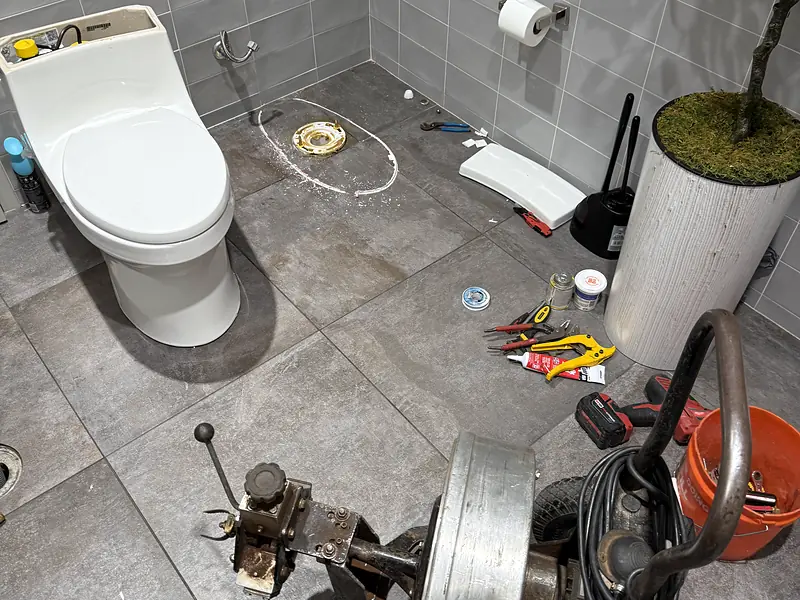 Drain machine in a commercial restroom with the toilet pulled