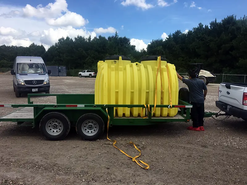 Large yellow grease interceptor tank on a trailer at a commercial site