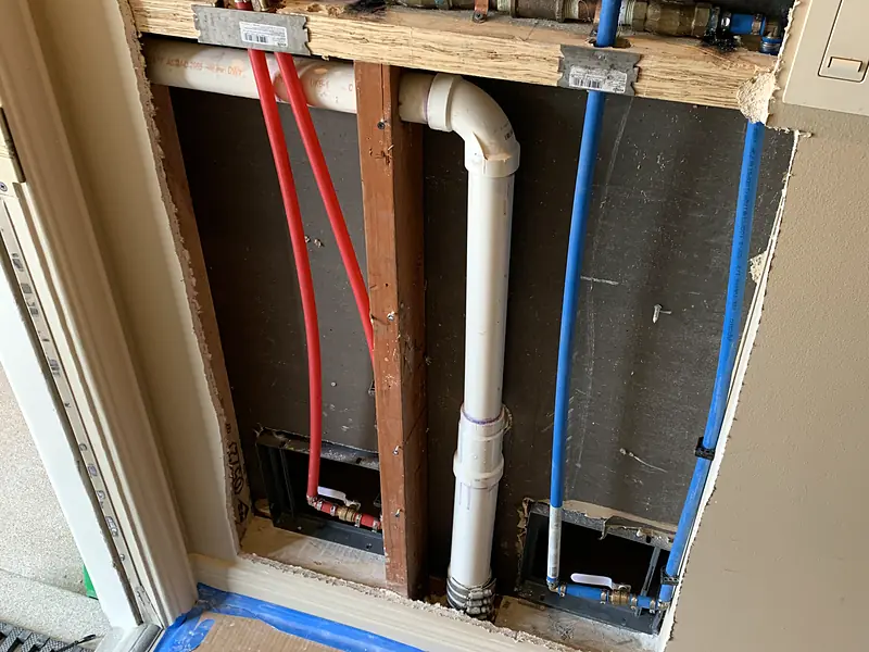 Red and blue PEX lines roughed in inside a wall