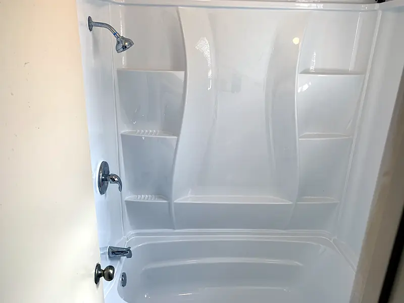 New white tub with a surround and shower head