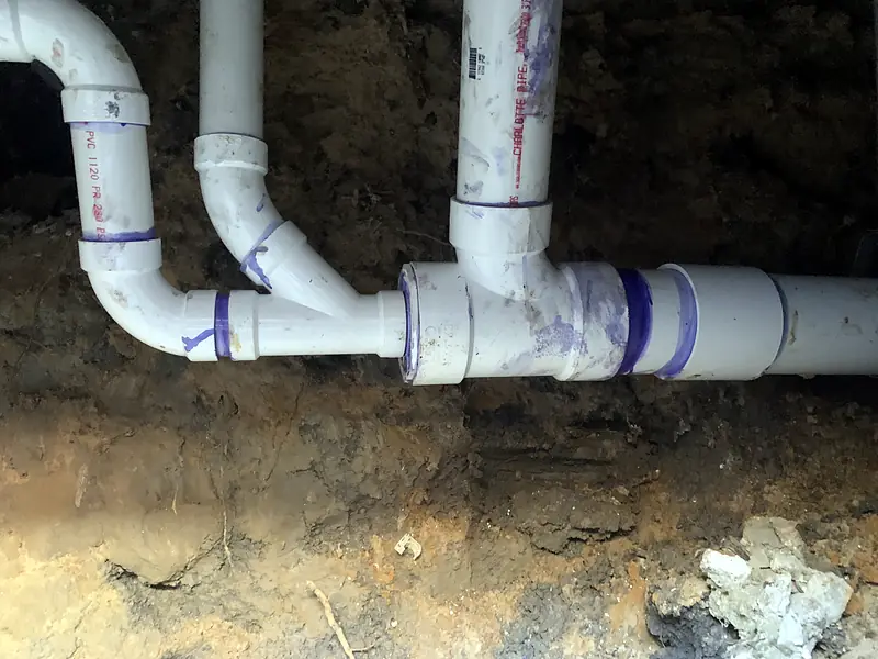 New PVC drain fittings installed under a concrete slab