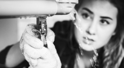 Woman fixing kitchen sink affordable-plumber-in-houston